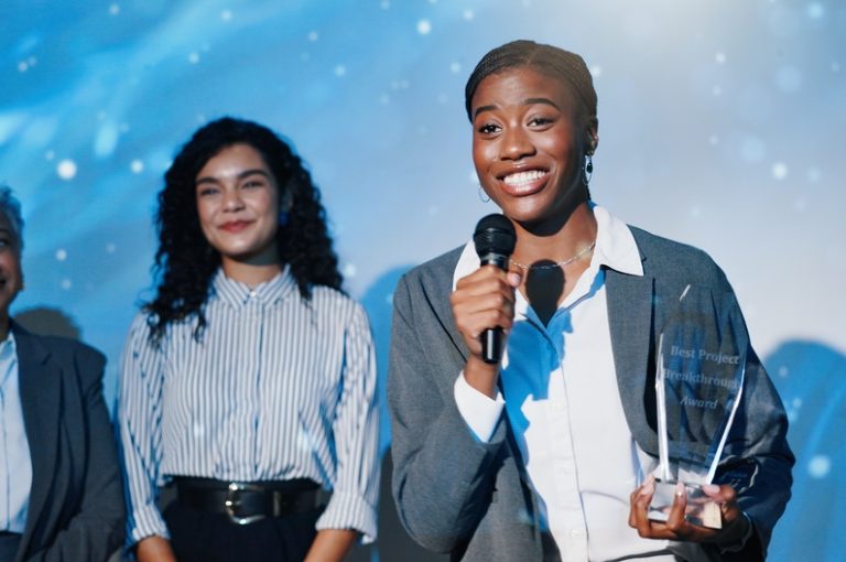 Women,,Award,And,Mic,On,Conference,Stage,,Happy,And,Giving